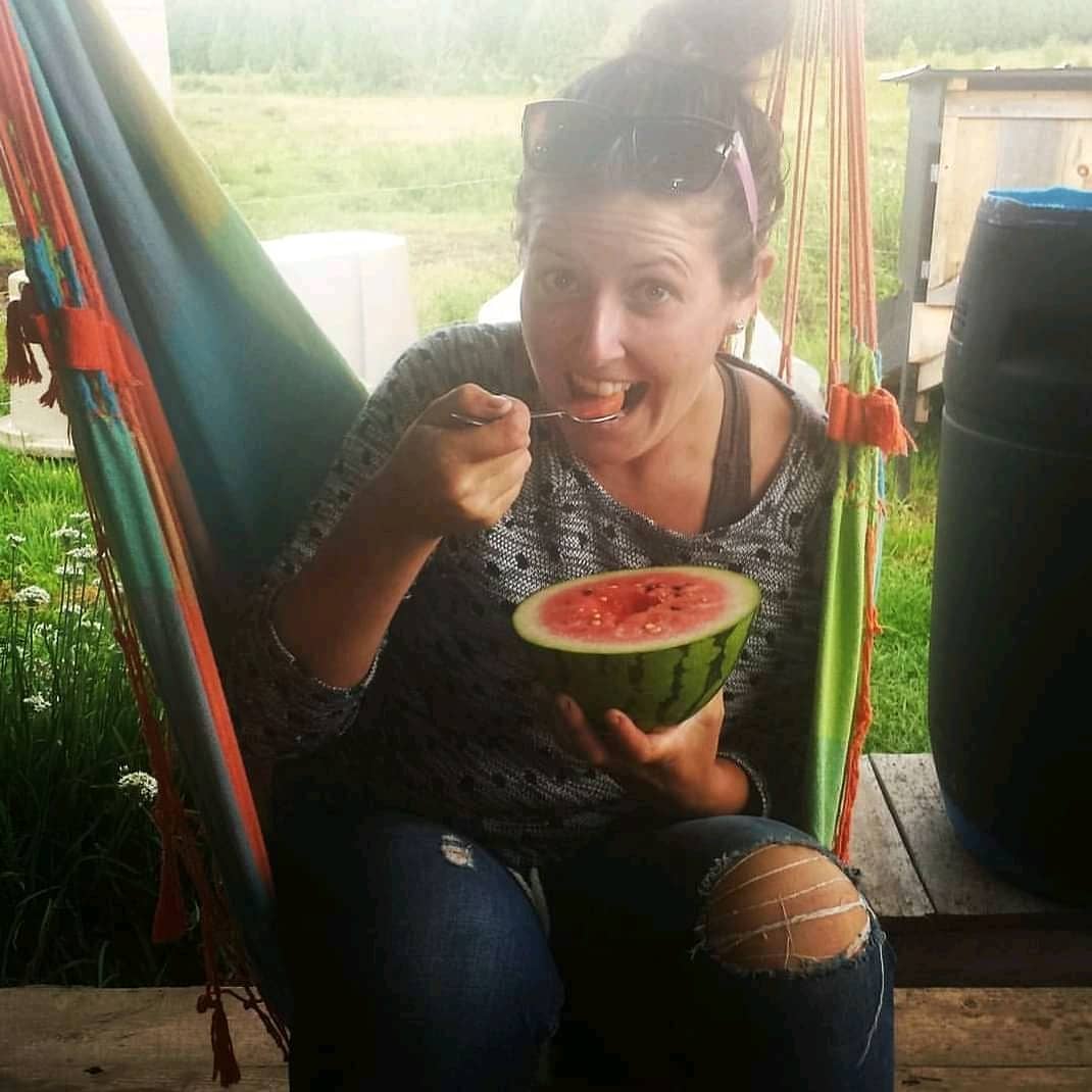 Chef Jillian Hillier sitting on a hammock and eating watermelon